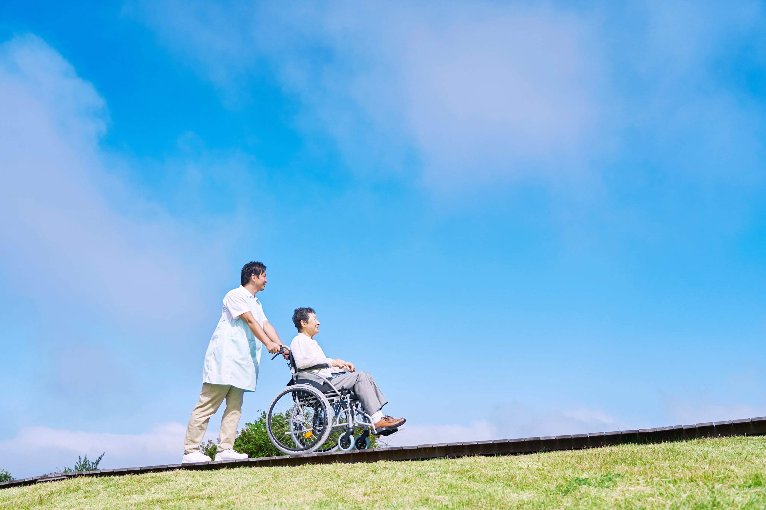 利用者さんと河川敷を散歩しているスタッフ